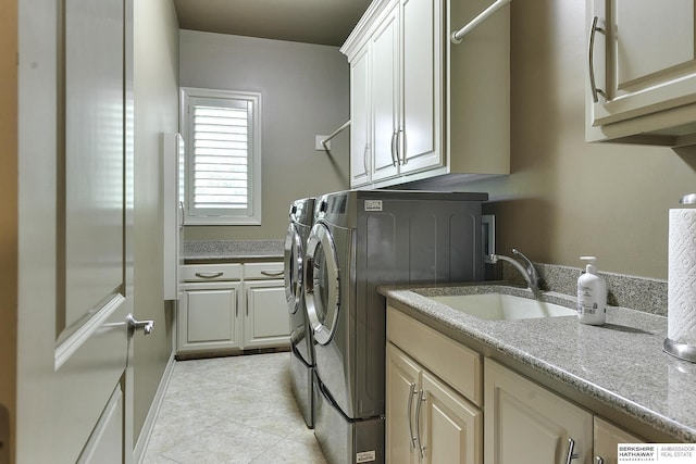 washroom with cabinets, independent washer and dryer, and sink