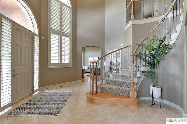 entryway featuring light tile patterned floors and a high ceiling