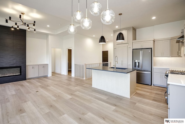 kitchen with stainless steel appliances, gray cabinetry, hanging light fixtures, and sink