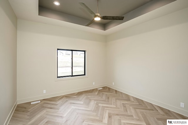 spare room featuring ceiling fan and a tray ceiling