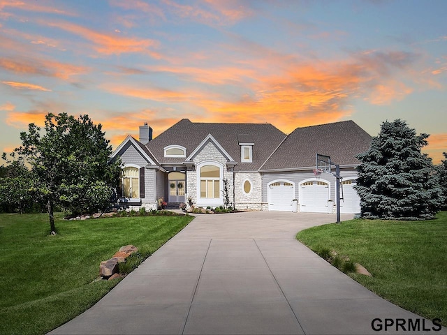 french country style house featuring a garage and a yard