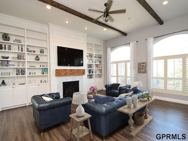 living room featuring a high end fireplace, dark hardwood / wood-style flooring, ceiling fan, beam ceiling, and built in features