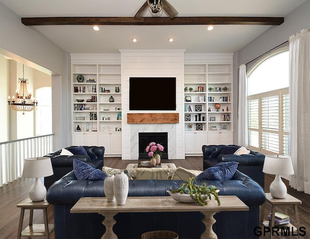 living room with a fireplace, ceiling fan with notable chandelier, dark hardwood / wood-style floors, and built in features