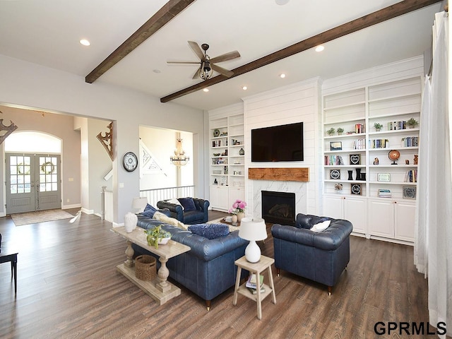 living room with french doors, built in shelves, ceiling fan, a premium fireplace, and dark hardwood / wood-style flooring