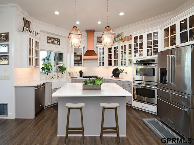 kitchen featuring premium range hood, white cabinetry, a center island, and appliances with stainless steel finishes