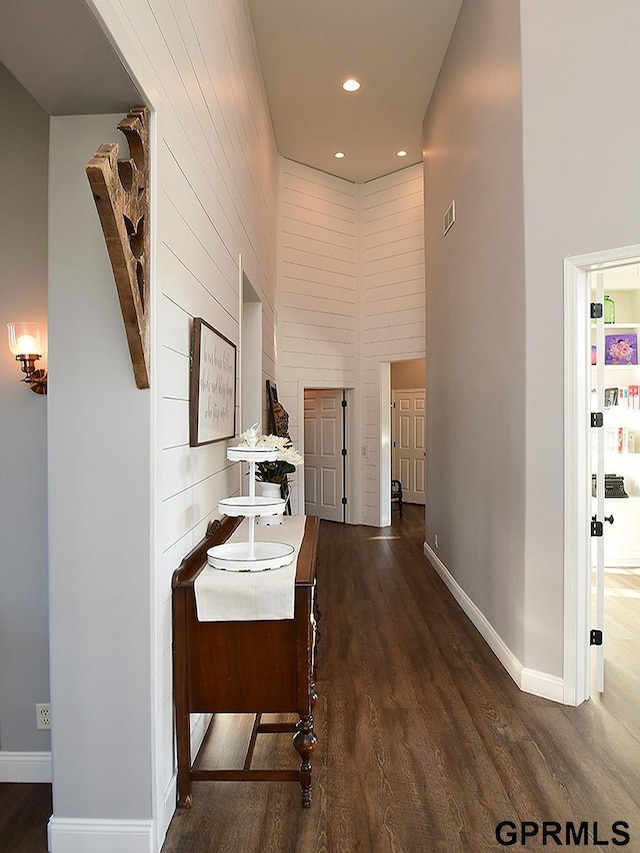 corridor featuring dark wood-type flooring and a high ceiling