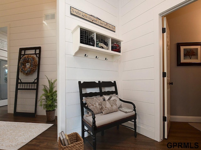 mudroom featuring dark hardwood / wood-style floors and wooden walls