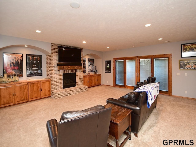 carpeted living room featuring a fireplace and a textured ceiling