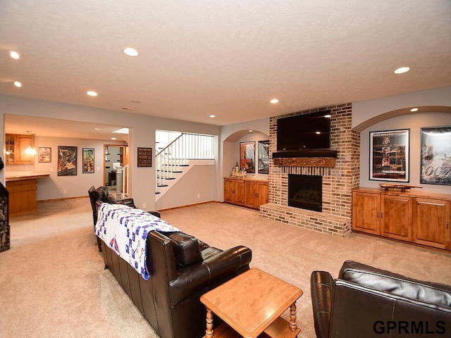 carpeted living room with a fireplace and a textured ceiling