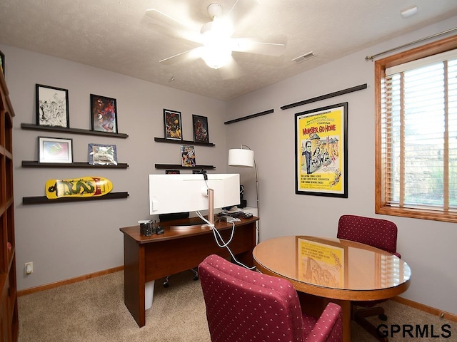 carpeted home office with ceiling fan and a textured ceiling