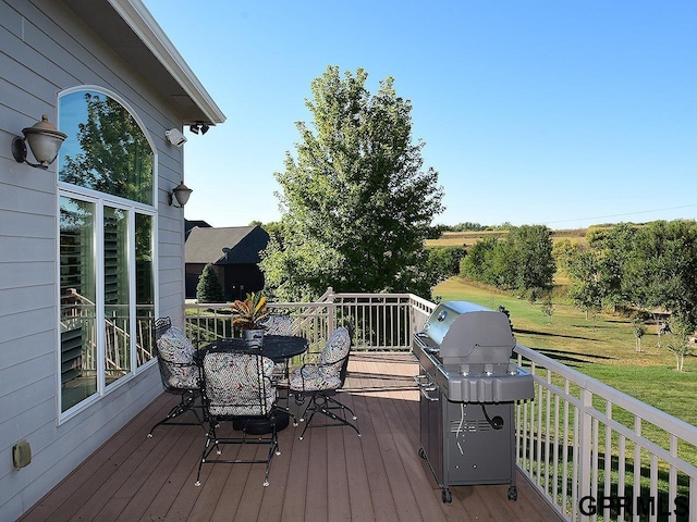 wooden deck featuring a lawn and grilling area