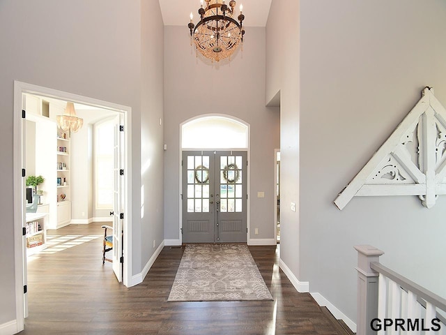 entryway featuring a notable chandelier, dark hardwood / wood-style flooring, a towering ceiling, and french doors