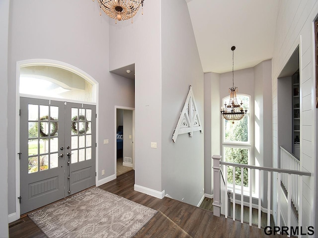 entrance foyer featuring a high ceiling, dark hardwood / wood-style flooring, plenty of natural light, and a notable chandelier