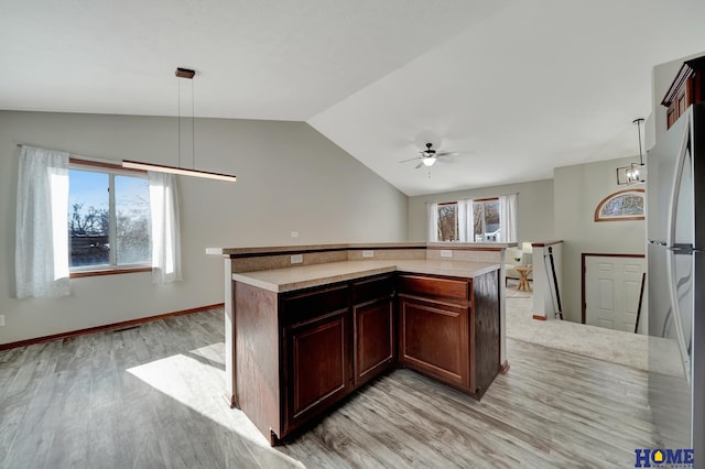 kitchen with stainless steel refrigerator, light wood-type flooring, ceiling fan, and hanging light fixtures