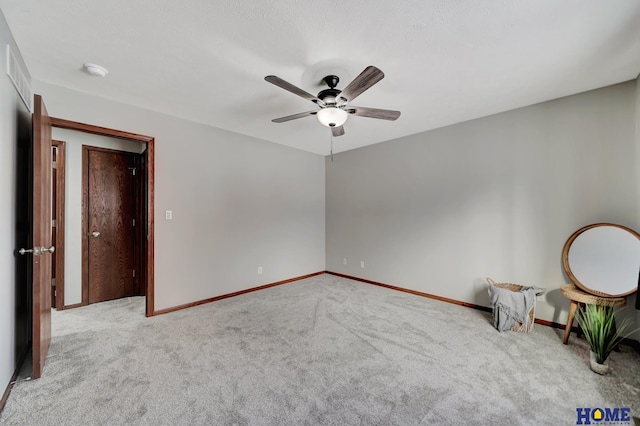 carpeted spare room featuring ceiling fan