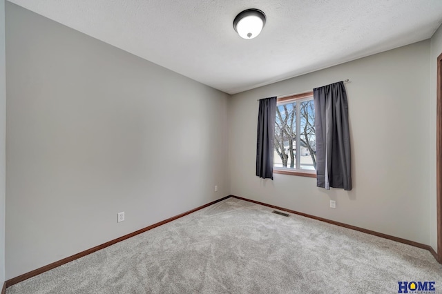 unfurnished room with a textured ceiling and carpet flooring