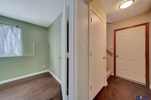 hallway featuring a textured ceiling and dark hardwood / wood-style flooring