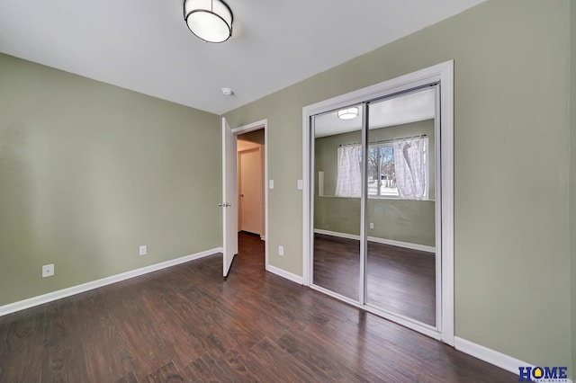 unfurnished bedroom featuring a closet and dark hardwood / wood-style floors