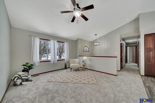 living area featuring ceiling fan with notable chandelier, vaulted ceiling, and light carpet