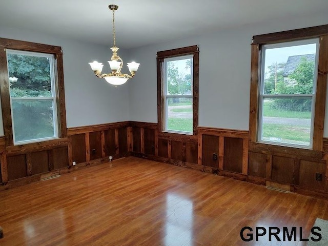 empty room featuring hardwood / wood-style floors and a notable chandelier