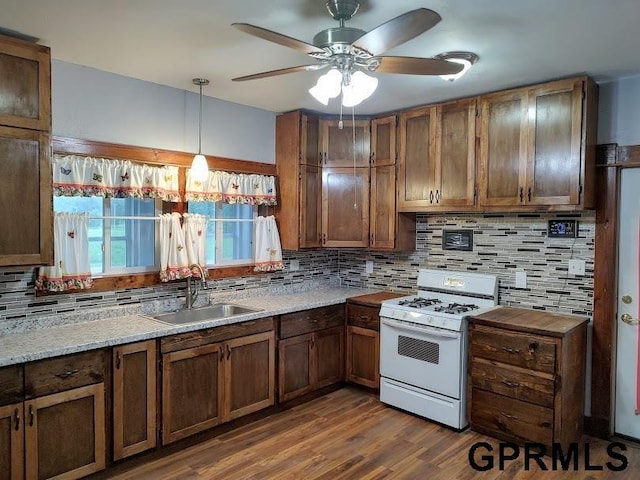 kitchen with ceiling fan, sink, dark wood-type flooring, white range, and pendant lighting