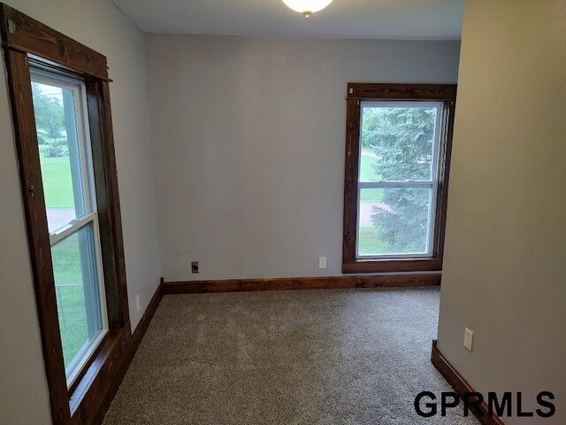 empty room featuring dark colored carpet