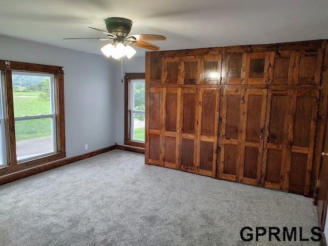 unfurnished bedroom featuring ceiling fan and light carpet