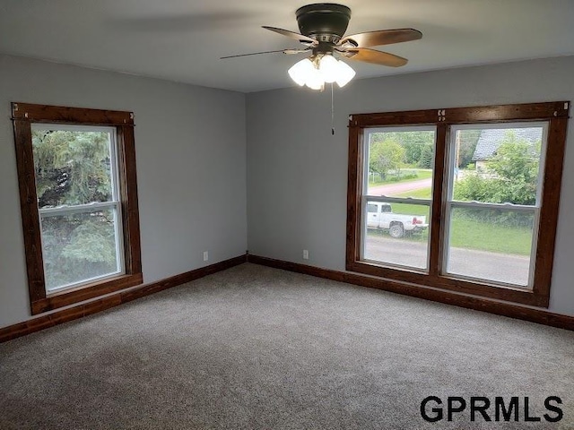 carpeted spare room featuring ceiling fan