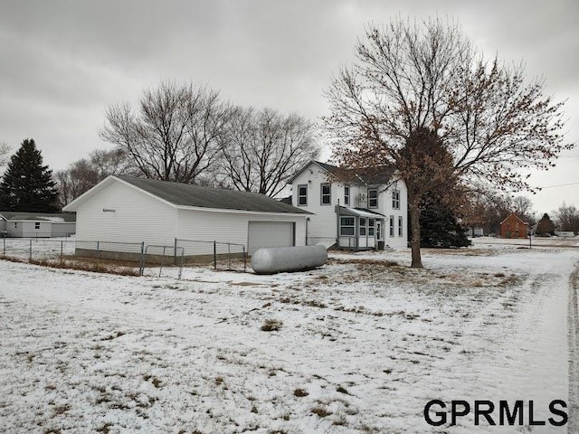 view of snowy exterior with a garage