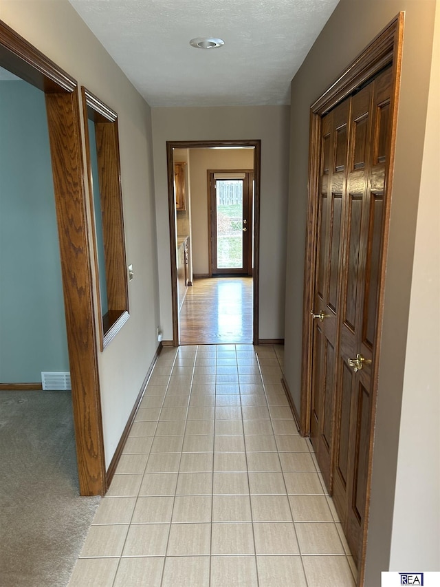 hall featuring light colored carpet