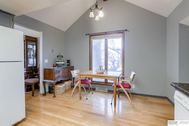 dining area with light wood-type flooring, lofted ceiling with beams, and a notable chandelier