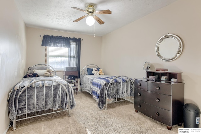 carpeted bedroom with ceiling fan and a textured ceiling