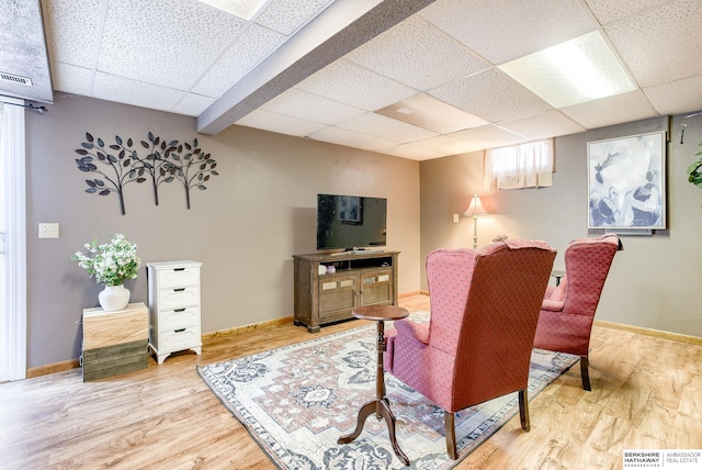 living room featuring hardwood / wood-style flooring and a paneled ceiling