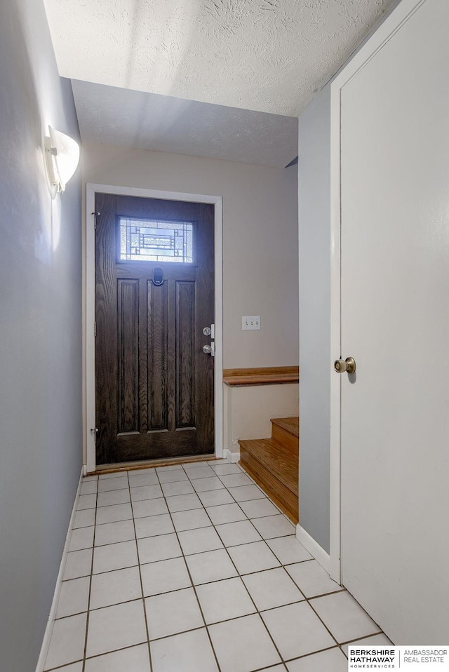 tiled foyer with a textured ceiling