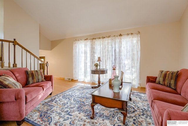 living room with vaulted ceiling and light wood-type flooring