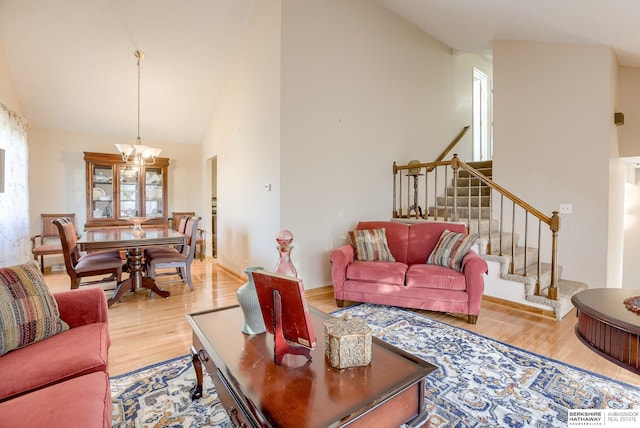 living room featuring hardwood / wood-style flooring, lofted ceiling, and a notable chandelier