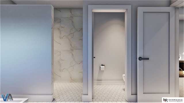 bathroom with toilet and tile patterned flooring