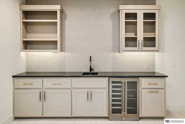 bar with beverage cooler, tasteful backsplash, and sink