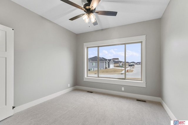 empty room featuring ceiling fan and light colored carpet