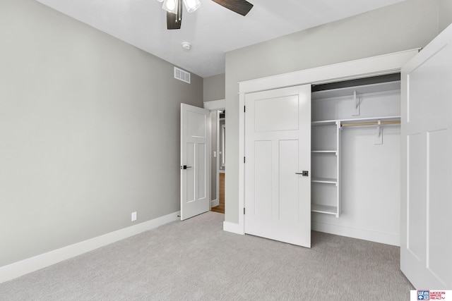 unfurnished bedroom with light carpet, a closet, and ceiling fan