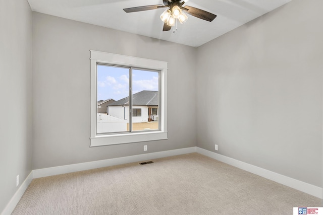 spare room featuring light colored carpet and ceiling fan