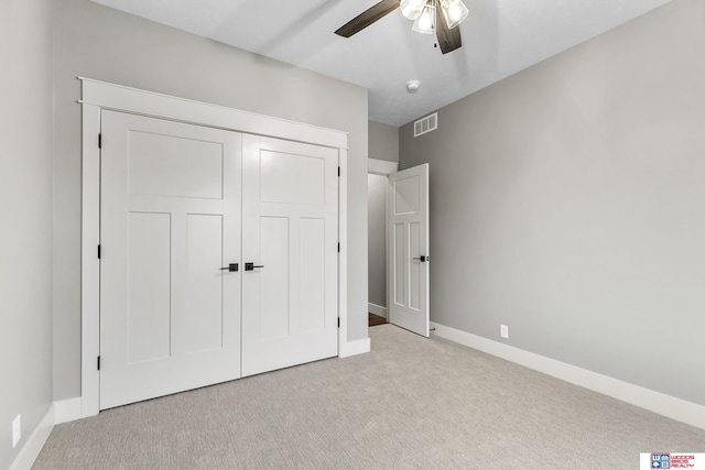 unfurnished bedroom featuring light carpet, a closet, and ceiling fan