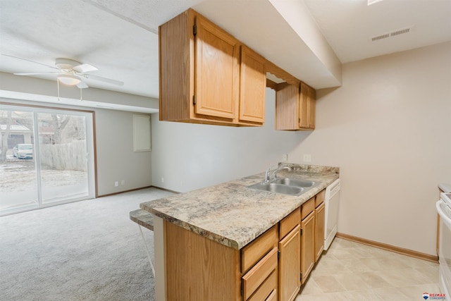 kitchen featuring white dishwasher, sink, ceiling fan, light colored carpet, and range