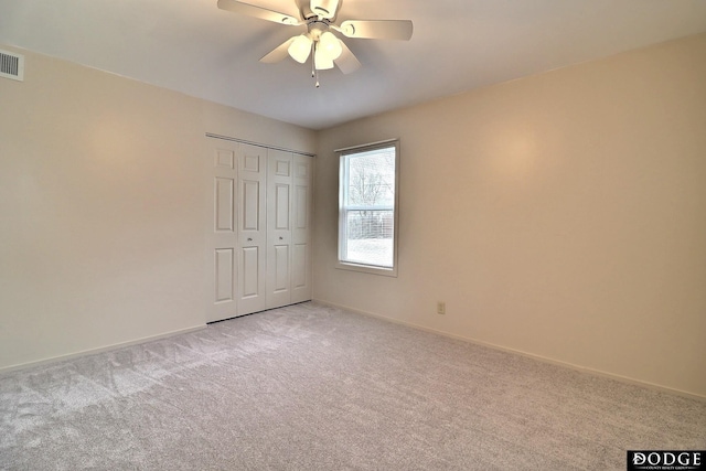 unfurnished bedroom with ceiling fan, a closet, and light colored carpet