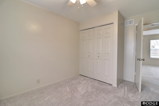 unfurnished bedroom with a closet, ceiling fan, and light colored carpet