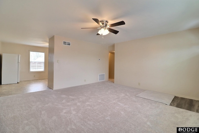 spare room with ceiling fan and carpet