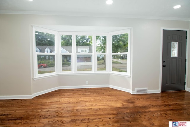 foyer with crown molding, dark hardwood / wood-style flooring, and a healthy amount of sunlight