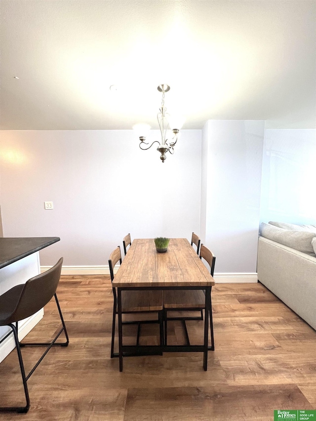 dining area with hardwood / wood-style floors and a notable chandelier