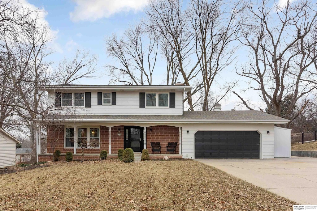 view of property with a front yard, a porch, and a garage