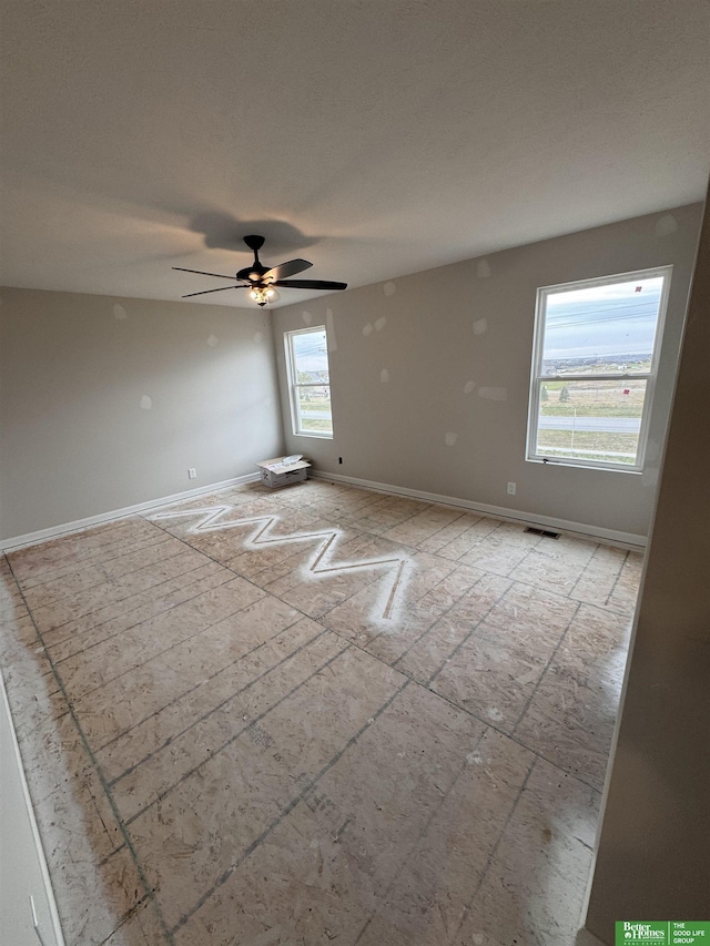 unfurnished room with ceiling fan and plenty of natural light